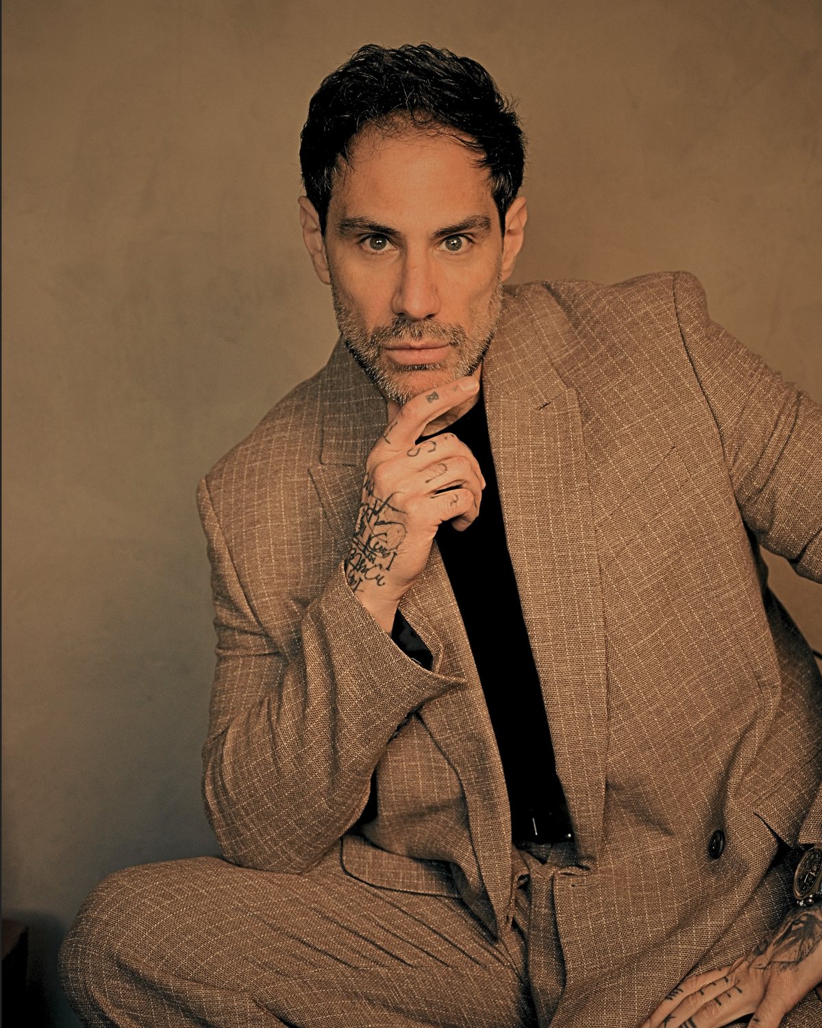 Max Daguano de terno, sentado